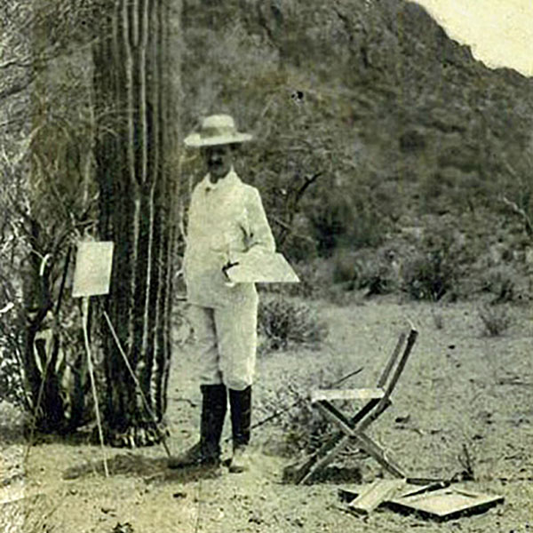 Audley Dean Nicols standing with canvases and cacti in Arizona